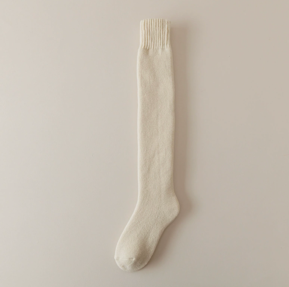 Knee high thermal socks in cream, a single over-the-calf sock shown flat.