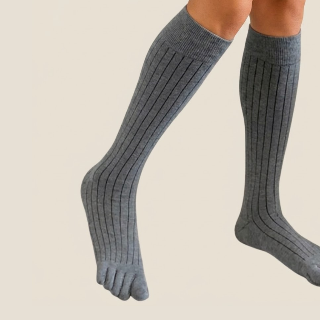 Knee high toe socks in grey ribbed knit, featuring a tall knee-high leg with five-toe styling. Worn on the legs.