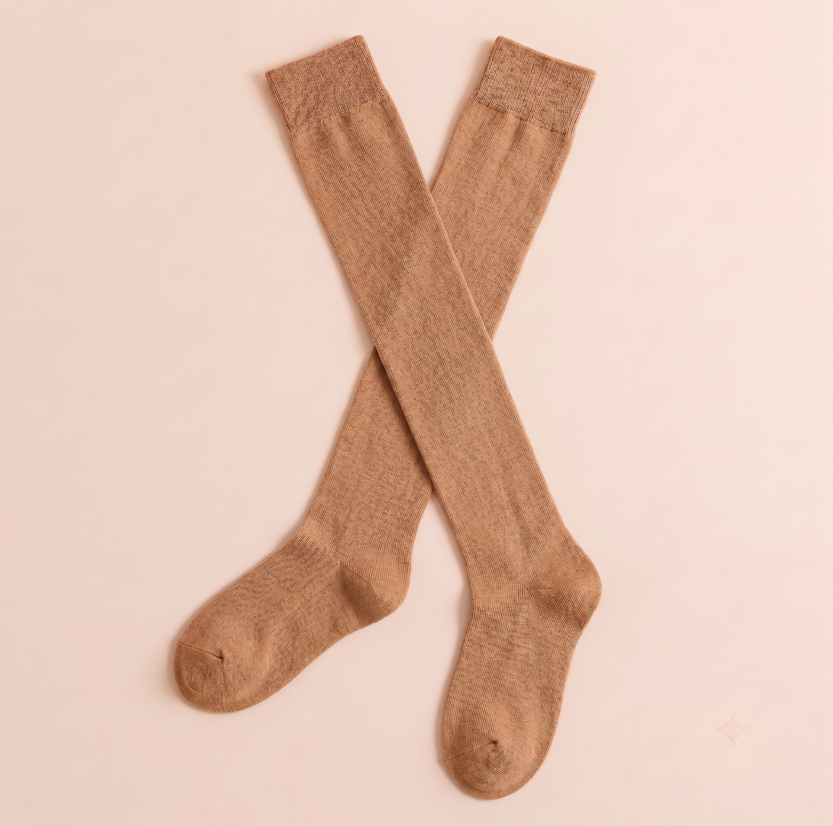 Women's knee high boot socks in camel tan, featuring a fine ribbed weave. Shown as a crossed pair on a warm surface.
