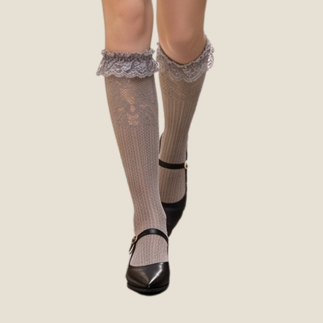 Lace knee high socks in taupe sheer knit, featuring a lace-trim cuff. Worn with mary jane flats.