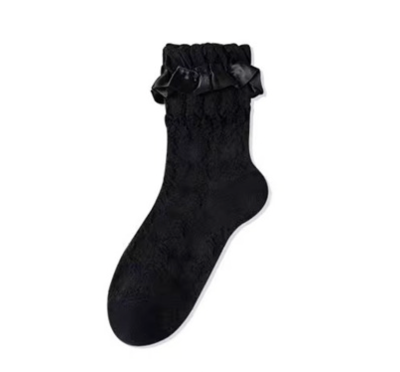 Lace socks for loafers in black with a textured knit and lace ruffle cuff, close-up of a single sock.
