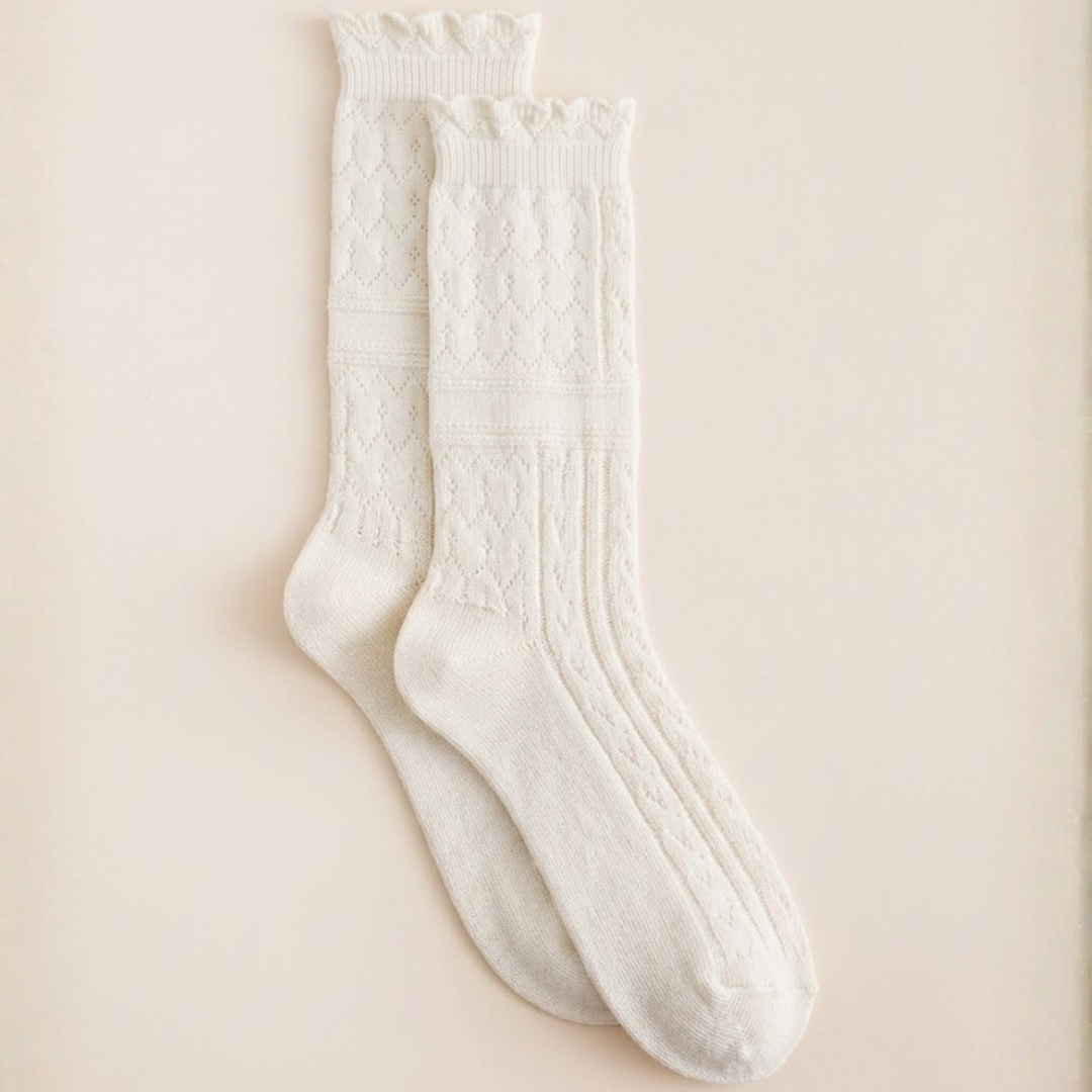 Ladies boot socks in white, featuring a textured cable knit. Shown as a flat-lay pair on a light surface.