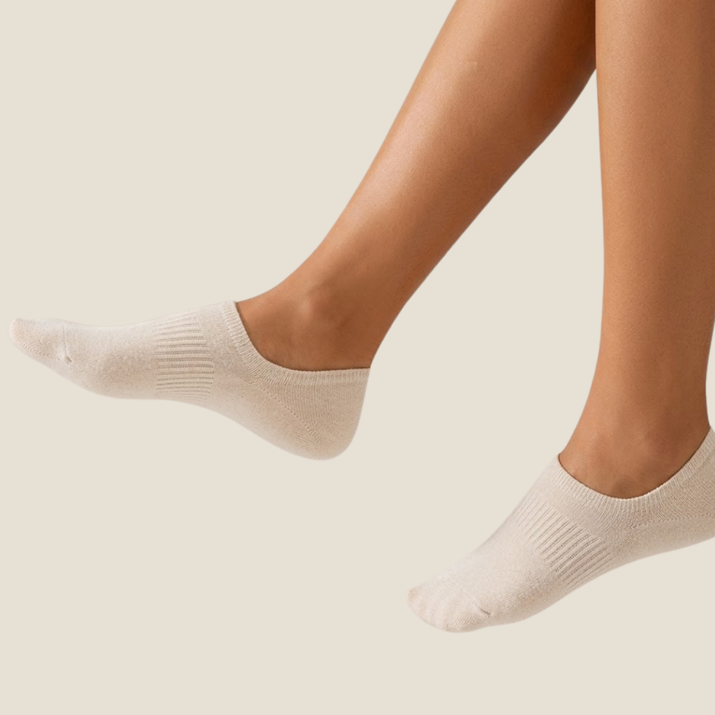 Low cut ankle socks in nude and white, featuring an invisible no-show design. Worn on feet to show the hidden cut.