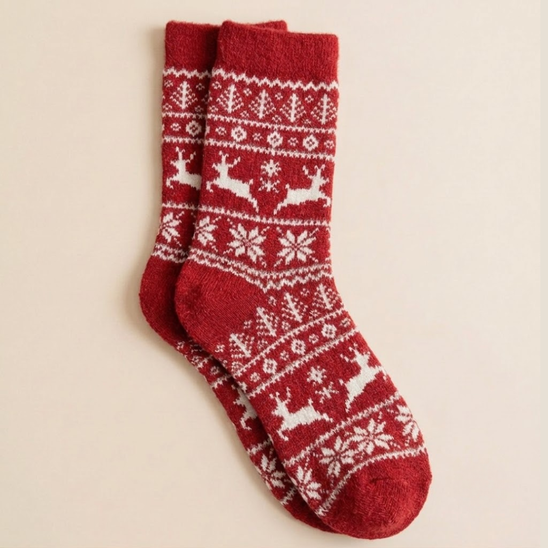 Luxury Christmas socks in red with a Nordic reindeer and snowflake pattern, flat-lay pair.