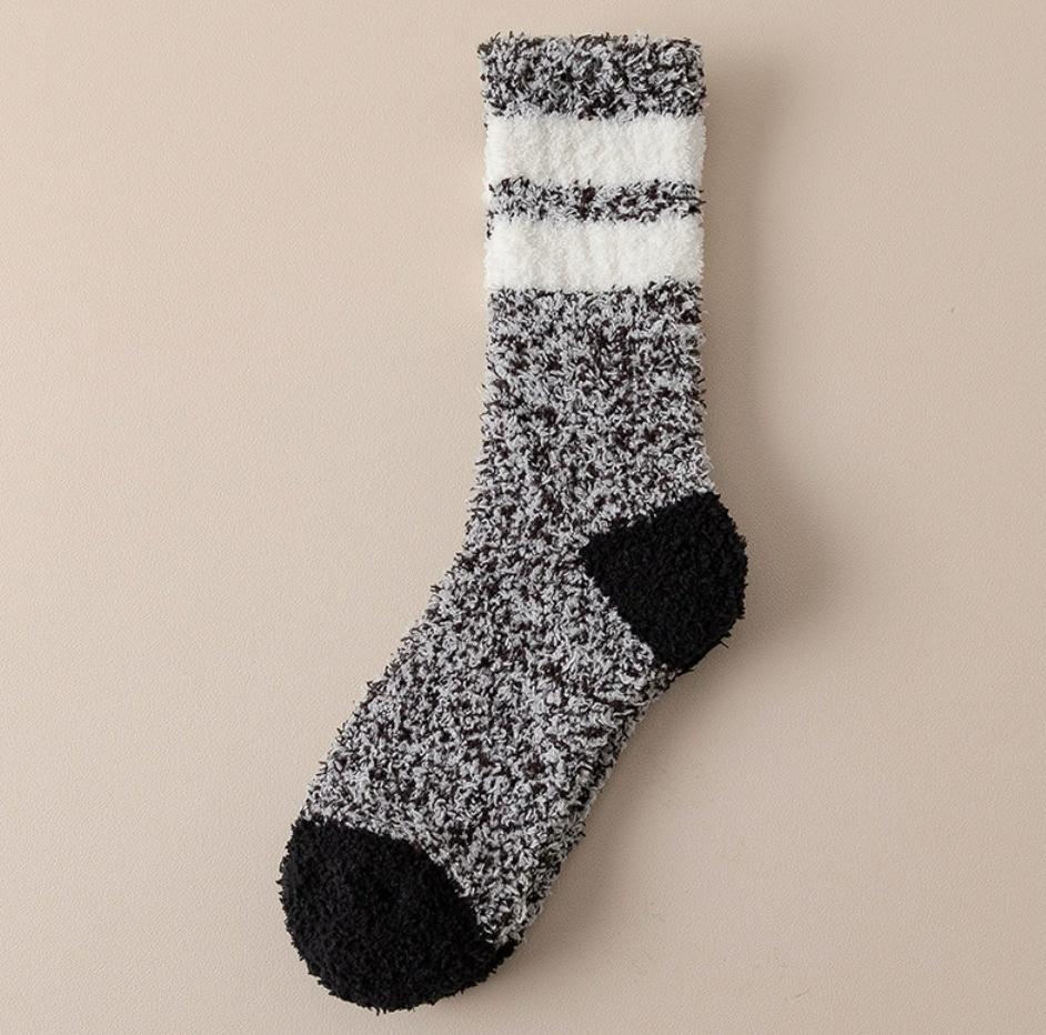 Men's cozy socks in black and white marl, featuring white stripes and a black heel and toe. Displayed flat to show the plush texture.