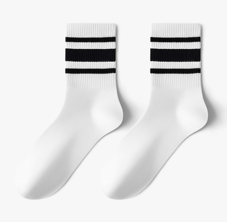Men's crew socks in white with black varsity stripes, featuring a cushioned knit. Displayed flat as a pair on a light surface.