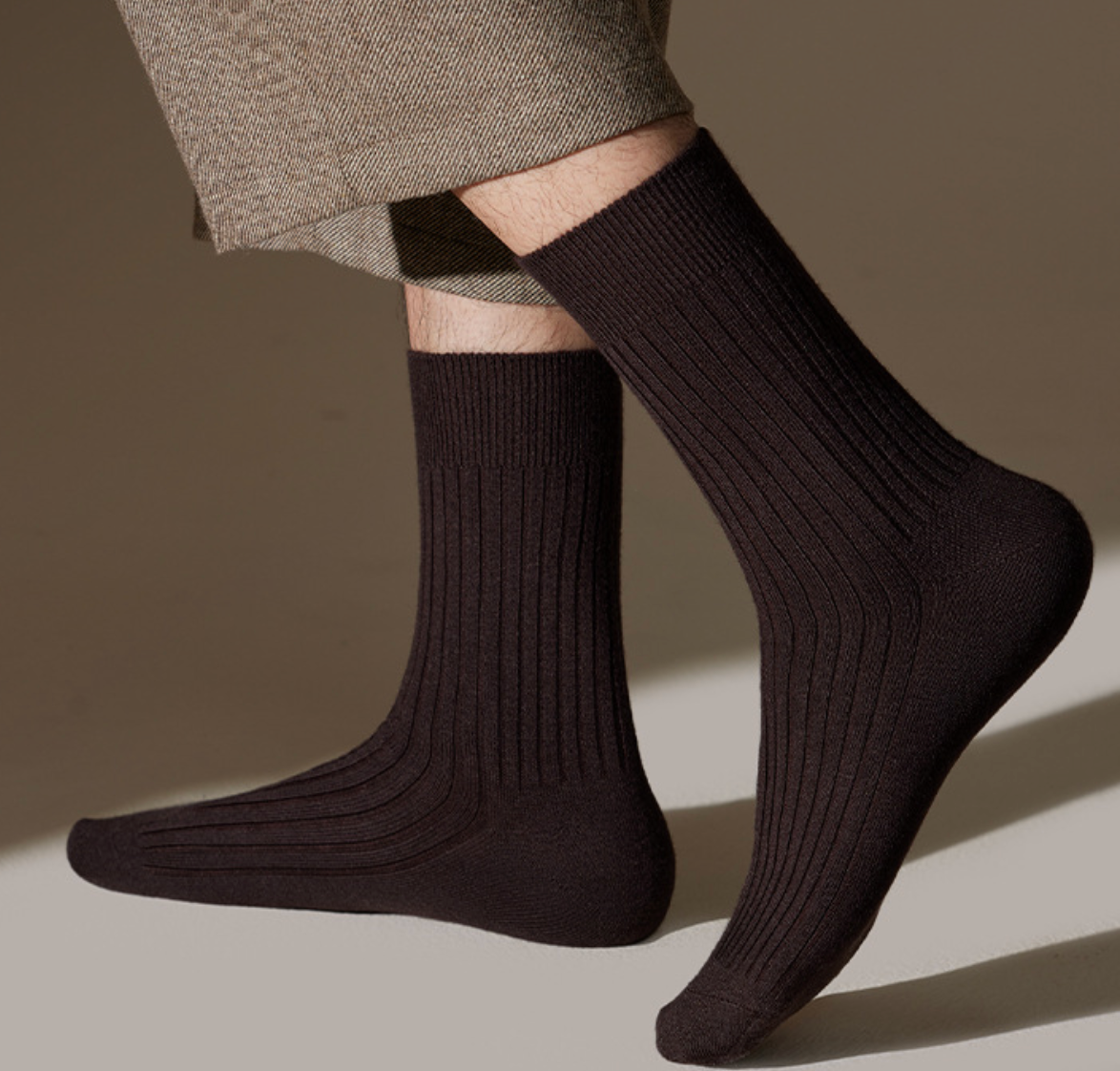 Men's merino wool dress socks in dark brown ribbed wool, featuring a smooth leg. Worn with trousers.