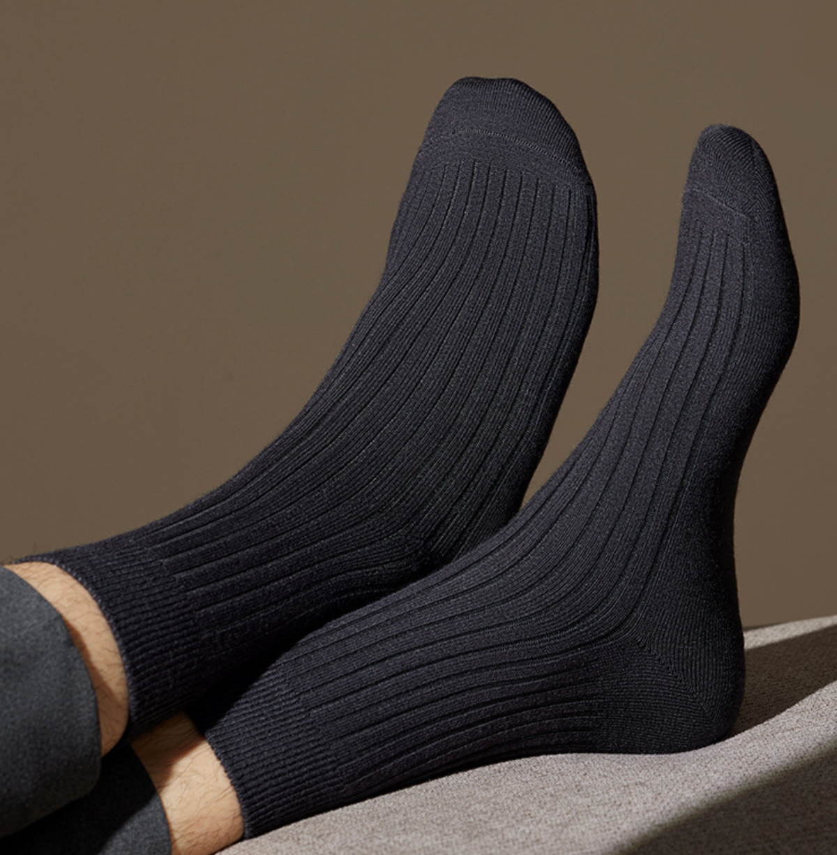 Men's merino wool dress socks in dark navy ribbed wool, featuring a warm knit. Shown on the feet to display the fit.