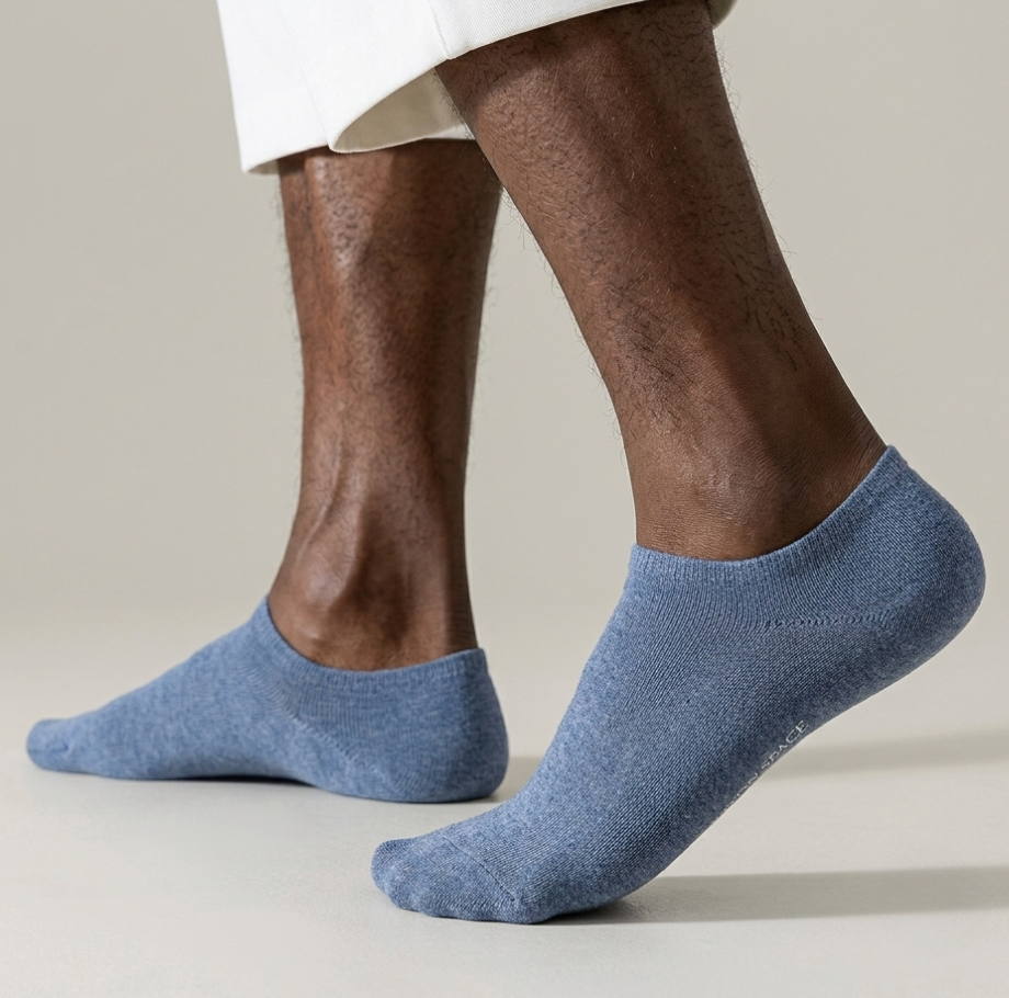 Men's no show socks in blue, featuring a hidden low-cut design. Worn on feet to display the invisible fit.