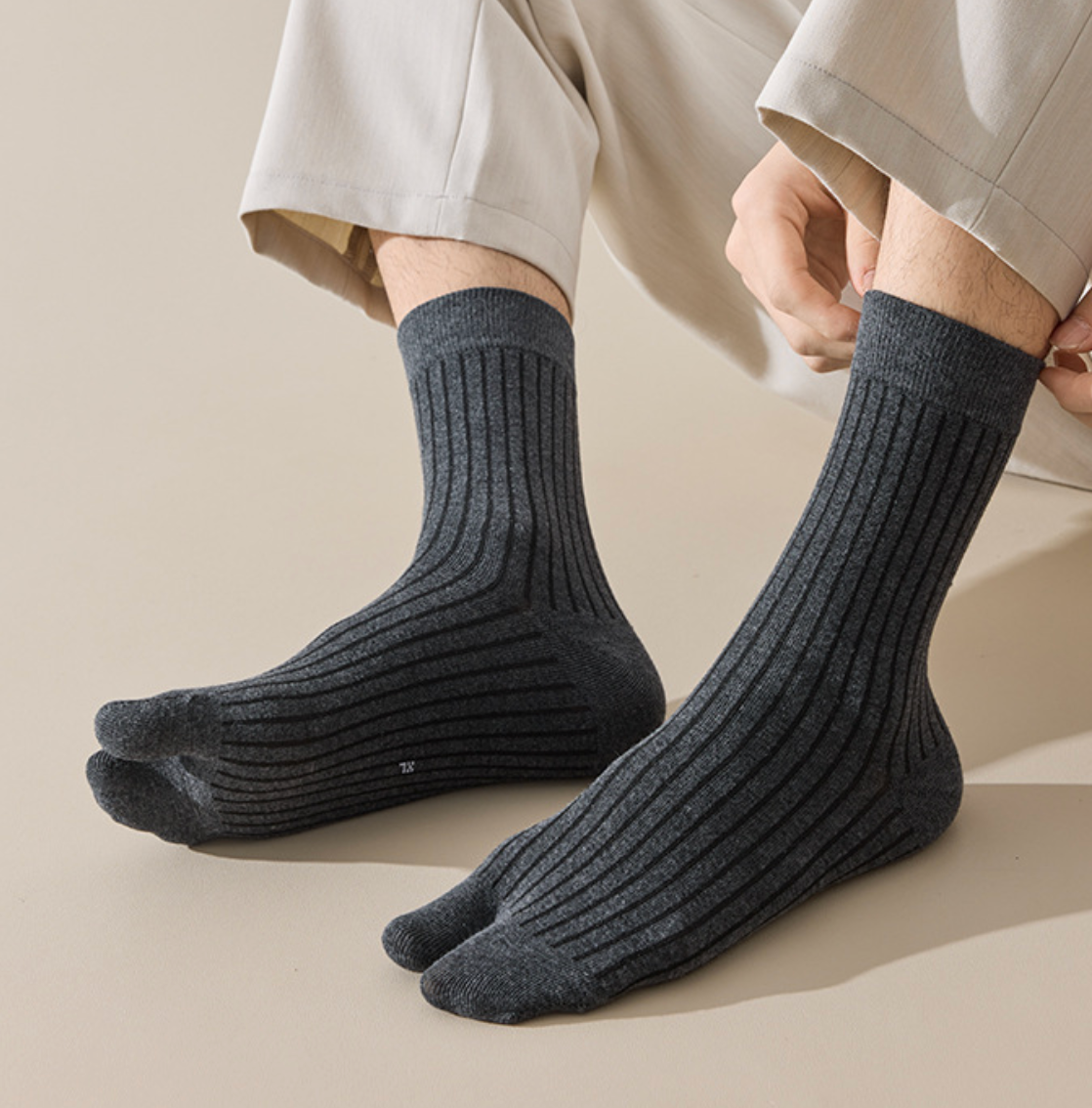 Men's tabi socks in dark charcoal, featuring a divided-toe design. Shown worn to display the tabi split.