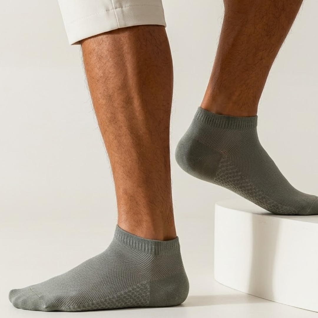 Men's thin ankle socks in grey, featuring a lightweight breathable knit. Worn on feet with rolled trousers.