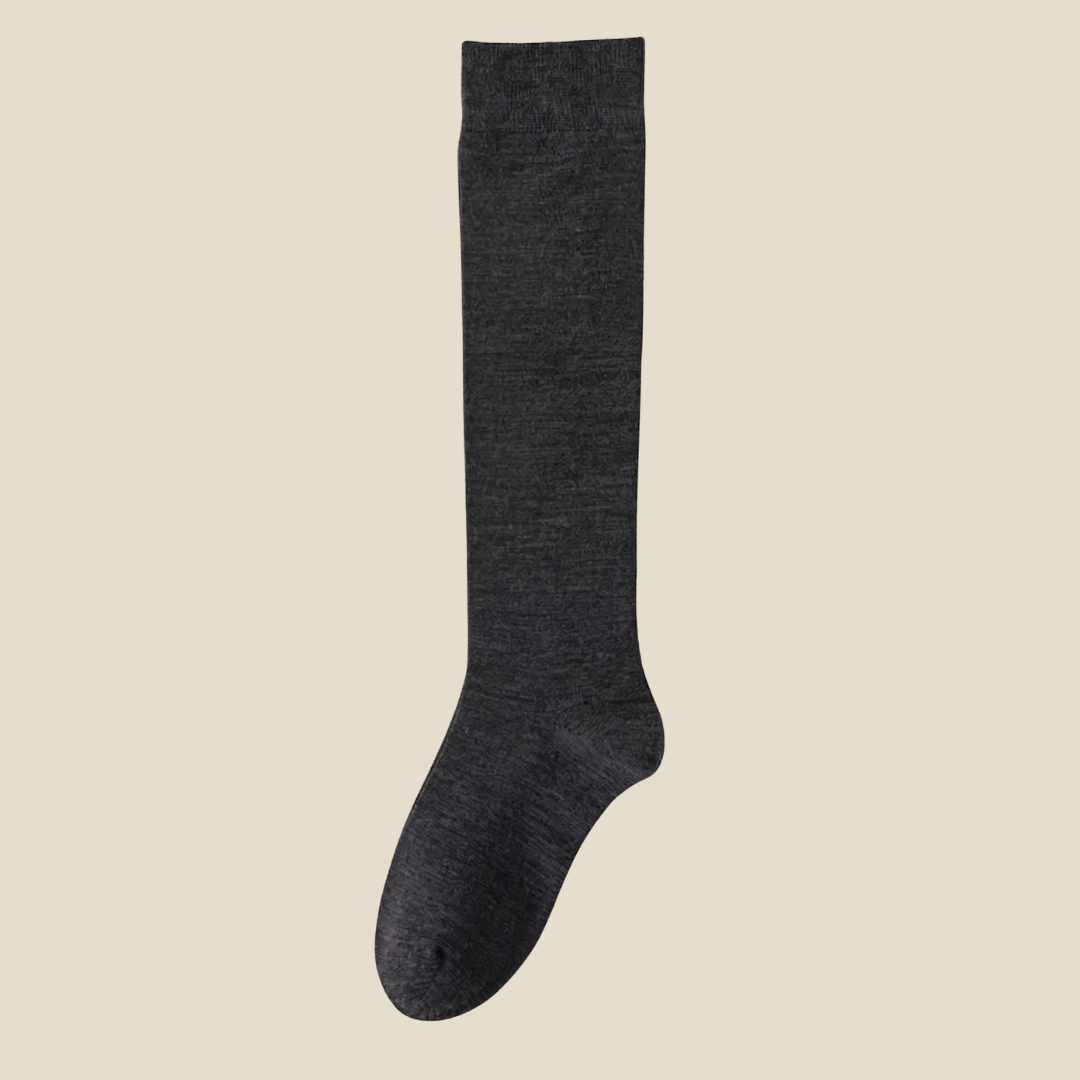 Merino knee socks in dark charcoal ribbed wool, featuring a stretchy cuff. Displayed to show the warm knee-high knit.