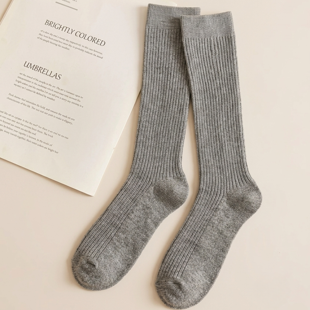 Merino wool boot socks in grey, featuring a soft ribbed knee-high knit. Shown as an upright pair beside a product card.