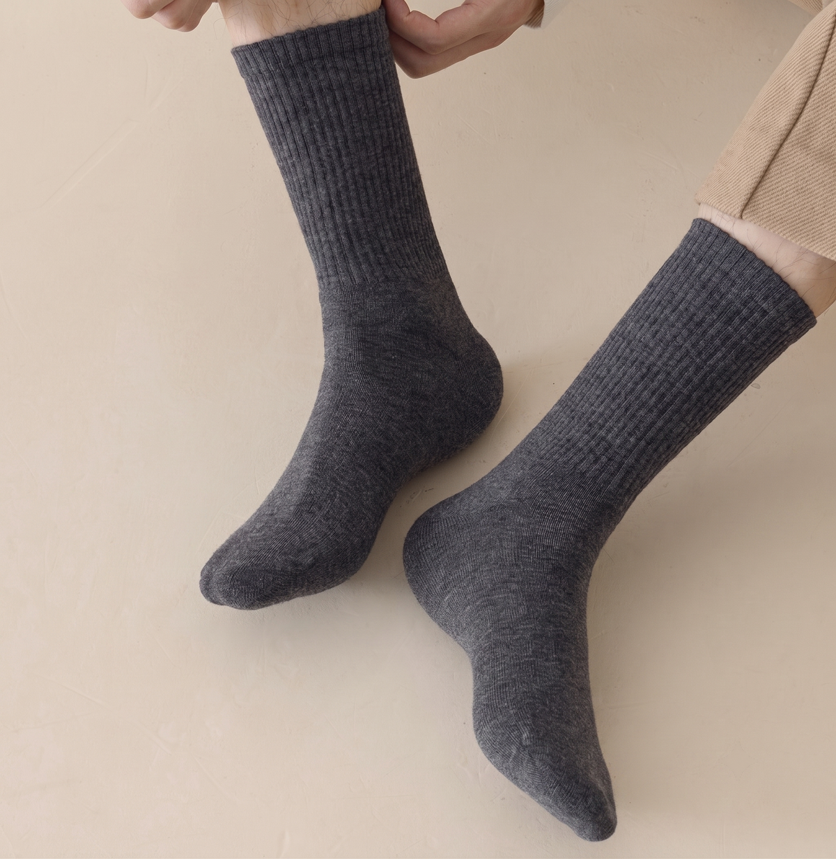 Men's merino wool dress socks in grey-blue ribbed wool, featuring a fine knit. Worn on the feet in a smart look.