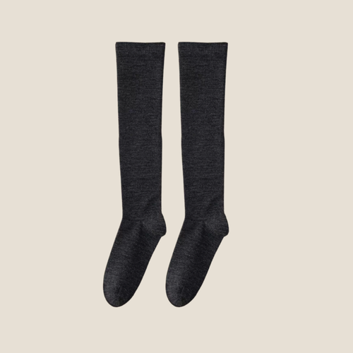 Merino wool knee socks in charcoal grey ribbed wool, featuring a smooth knee-high leg. Shown as an upright flat-lay pair on a neutral backdrop.