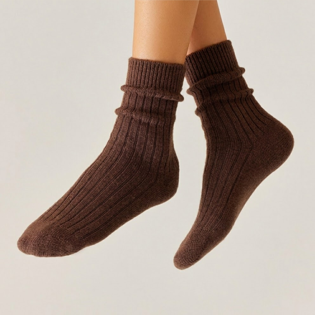 Merino wool sleep socks in espresso brown, featuring a ribbed slouch design. Worn on legs to show the drapey relaxed fit.