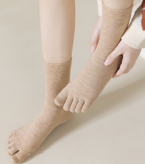 Merino wool toe socks in two-tone tan and cream, featuring individual toe pockets. Worn on the foot to show the color-block.