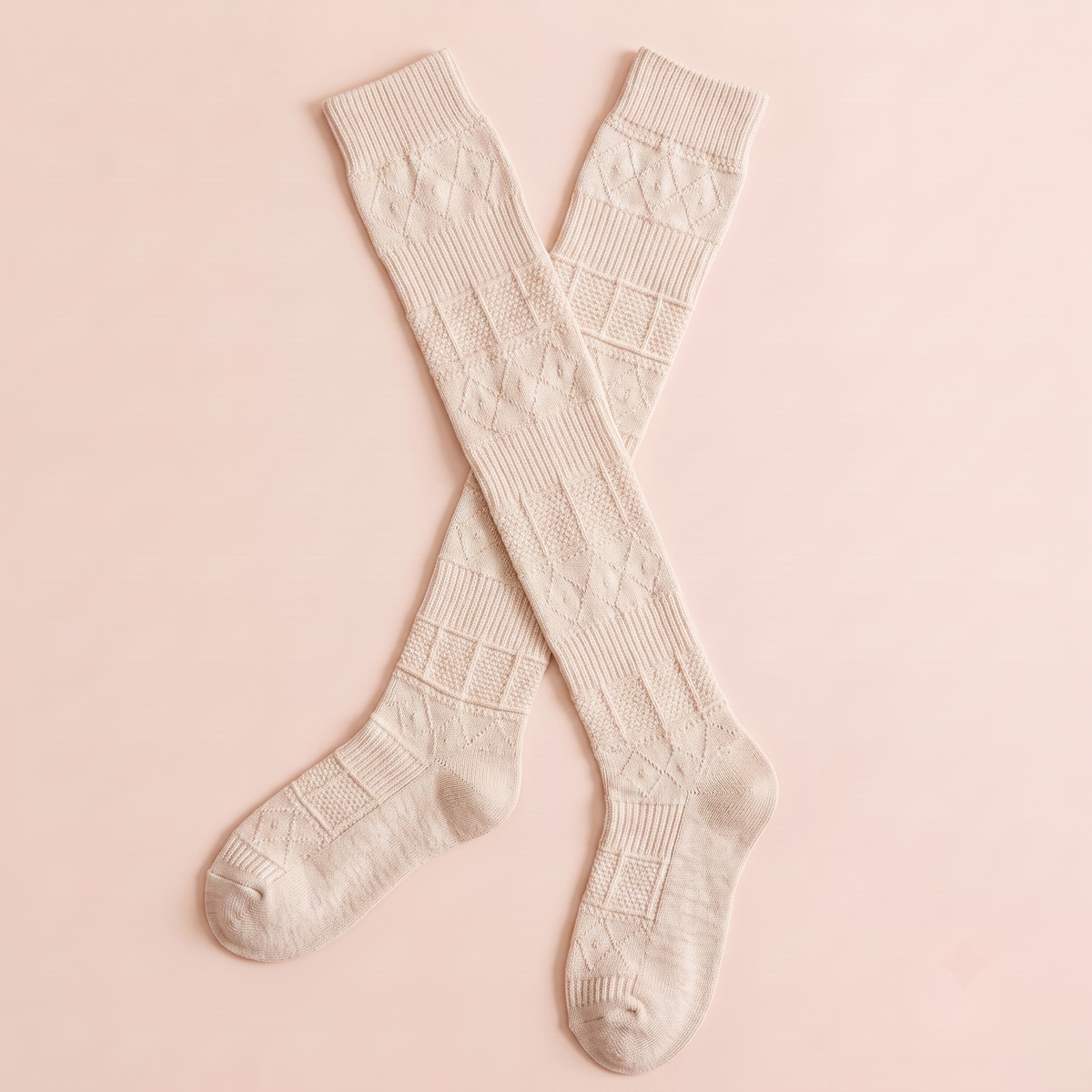 Mid calf boot socks in cream textured knit, featuring a subtle pointelle pattern. Shown as a crossed pair on a light surface.