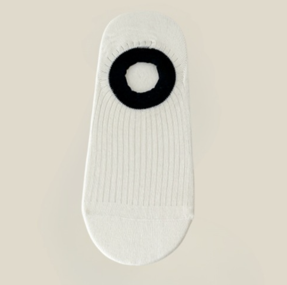 No show ankle socks in cream with a black grip detail, featuring an invisible cut. Displayed flat on a neutral surface.