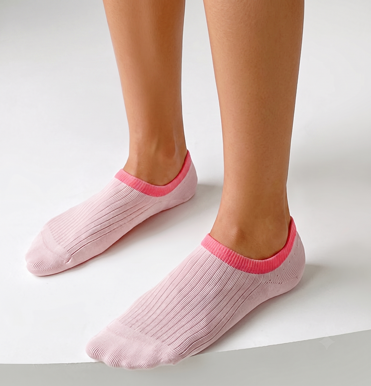 No show ankle socks in pink with a bright pink trim, featuring an invisible low-cut design. Worn on feet to show the hidden fit.