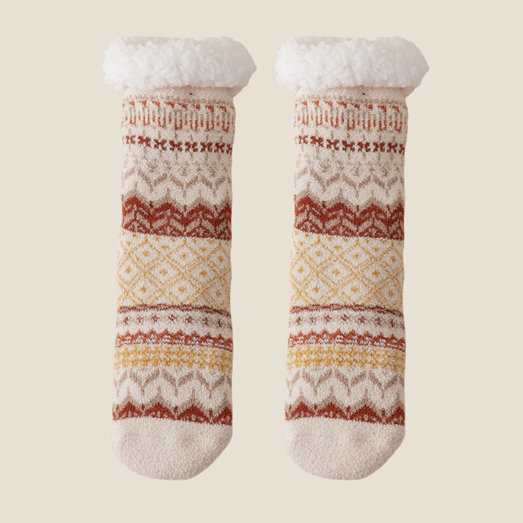 Non-skid slipper socks in cream and red Fair Isle knit, featuring a non-slip base. Displayed flat as a pair on a neutral surface.