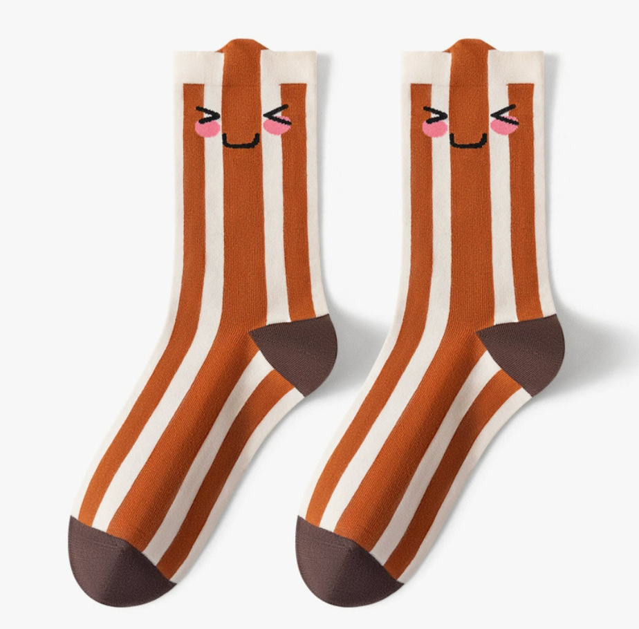 Novelty crew socks in rust brown with a cute animal face and white stripes, featuring a playful design. Shown as a flat-lay pair.