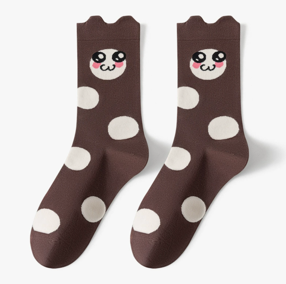 Novelty crew socks in dark brown with white polka dots and a cartoon animal face, featuring a fun motif. Displayed flat as a pair.