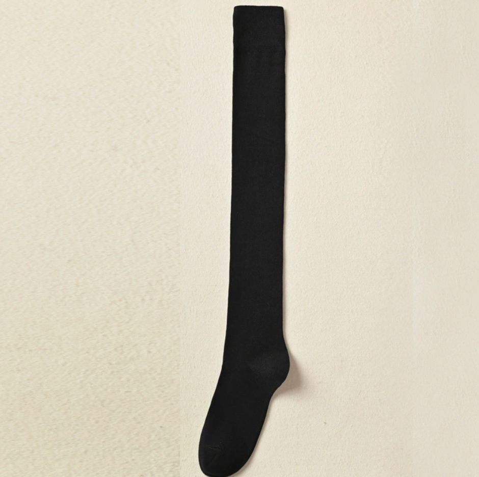 Over knee socks in black ribbed knit, featuring a smooth stretchy leg. Displayed flat on a neutral surface.