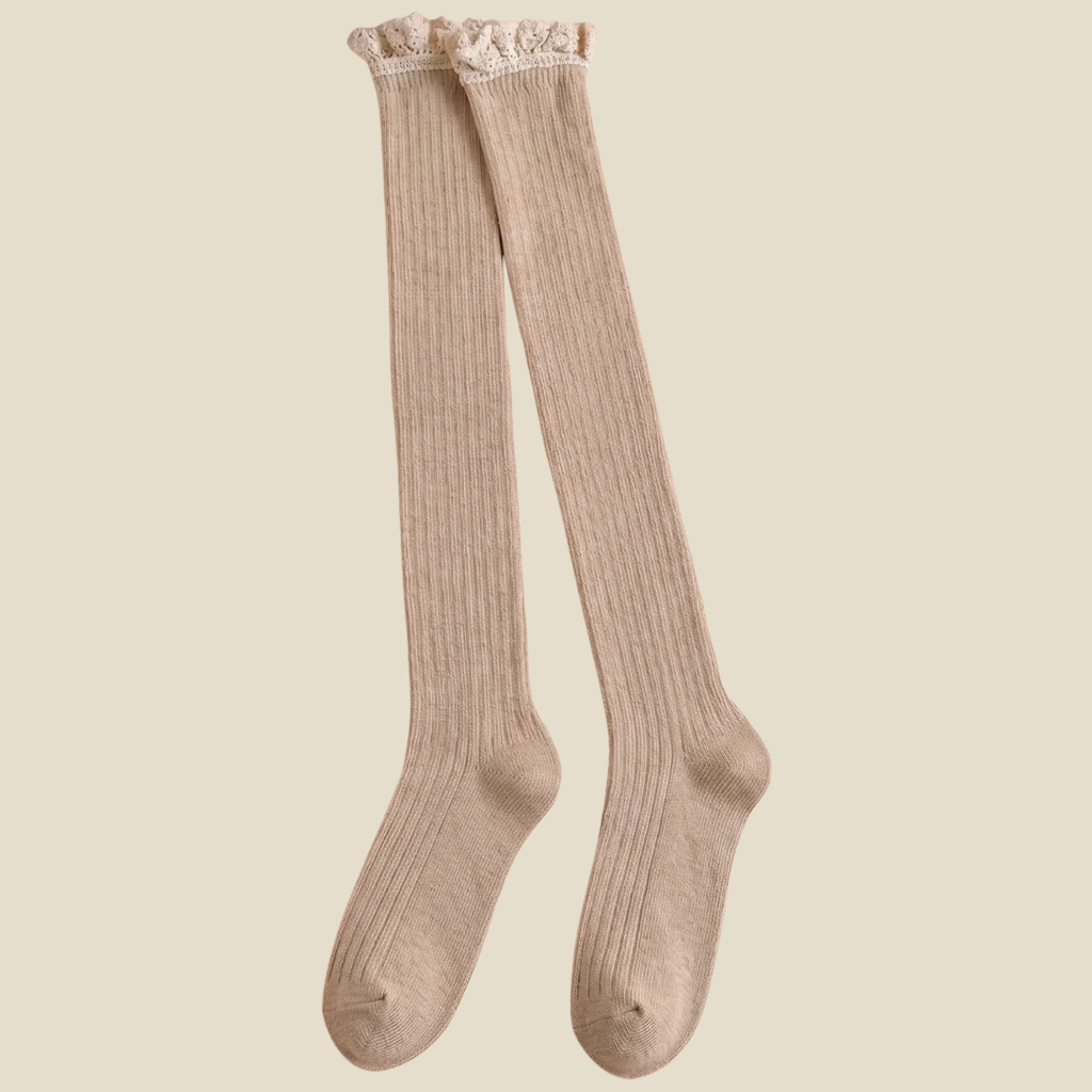 Over the knee boot socks in cream, featuring a ribbed knit with a long thigh-high leg. Shown as an upright pair on a neutral backdrop.