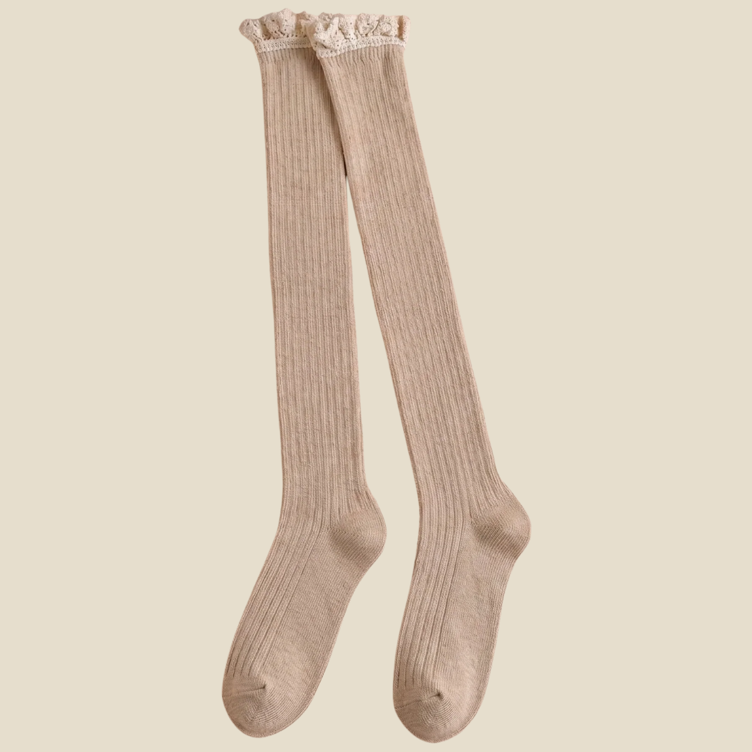 Over the knee boot socks in cream, featuring a ribbed knit with a long thigh-high leg. Shown as an upright pair on a neutral backdrop.