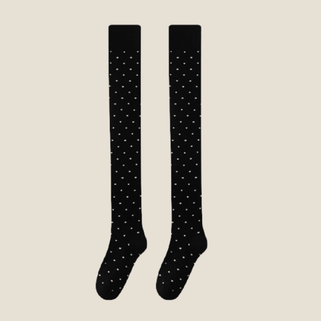 Over the knee socks in black with white polka dots, featuring a sheer thigh-high leg. Shown as an upright flat-lay pair.
