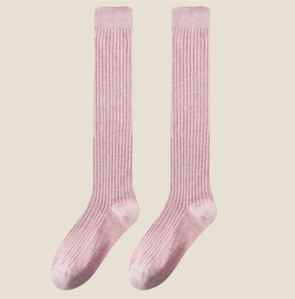 Over the knee socks for ladies in blush pink ribbed knit, featuring a soft thigh-high leg. Displayed flat as a pair on a neutral surface.