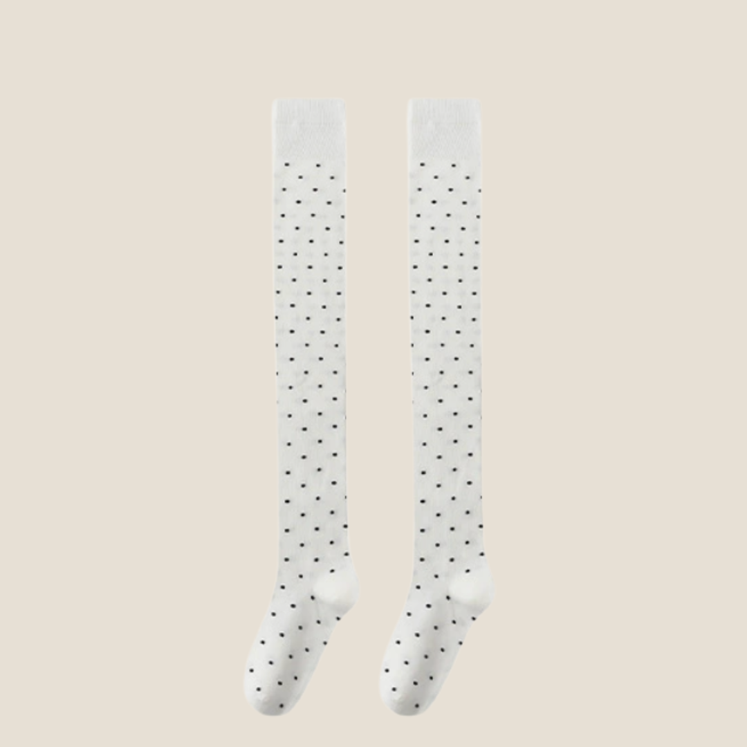Over the knee socks in white sheer knit with black dots, featuring a delicate pattern. Displayed flat as a pair.