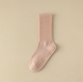 Pilates crew socks in blush pink ribbed knit, featuring grip dots on the sole. Shown as a single flat-lay.