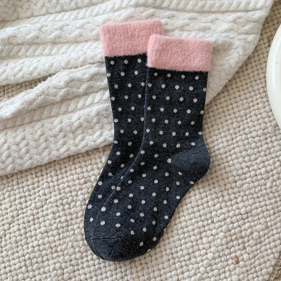 Pink fair isle socks in the navy polka-dot style with a pink cuff, flat-lay pair.
