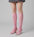 Pink knee socks in soft pink sheer knit, featuring a smooth leg. Styled with pink mary jane flats and a grey skirt.