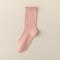 Pink ruffle socks in pink with a polka-dot pattern and lettuce-ruffle cuff, shown flat.