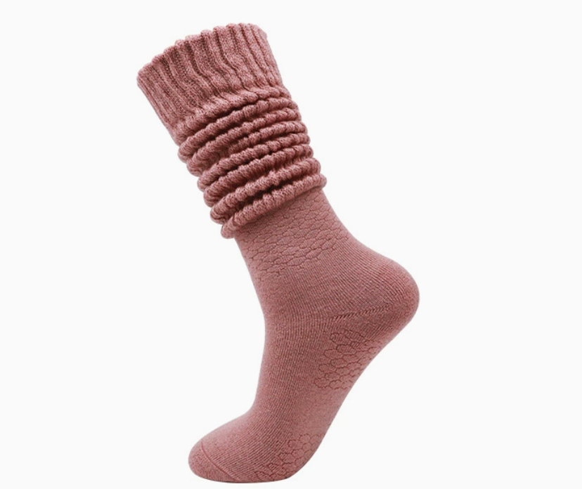 Pink slouch socks in rose knit, featuring a bunched slouchy leg. Worn on one foot to show the drapey fit.