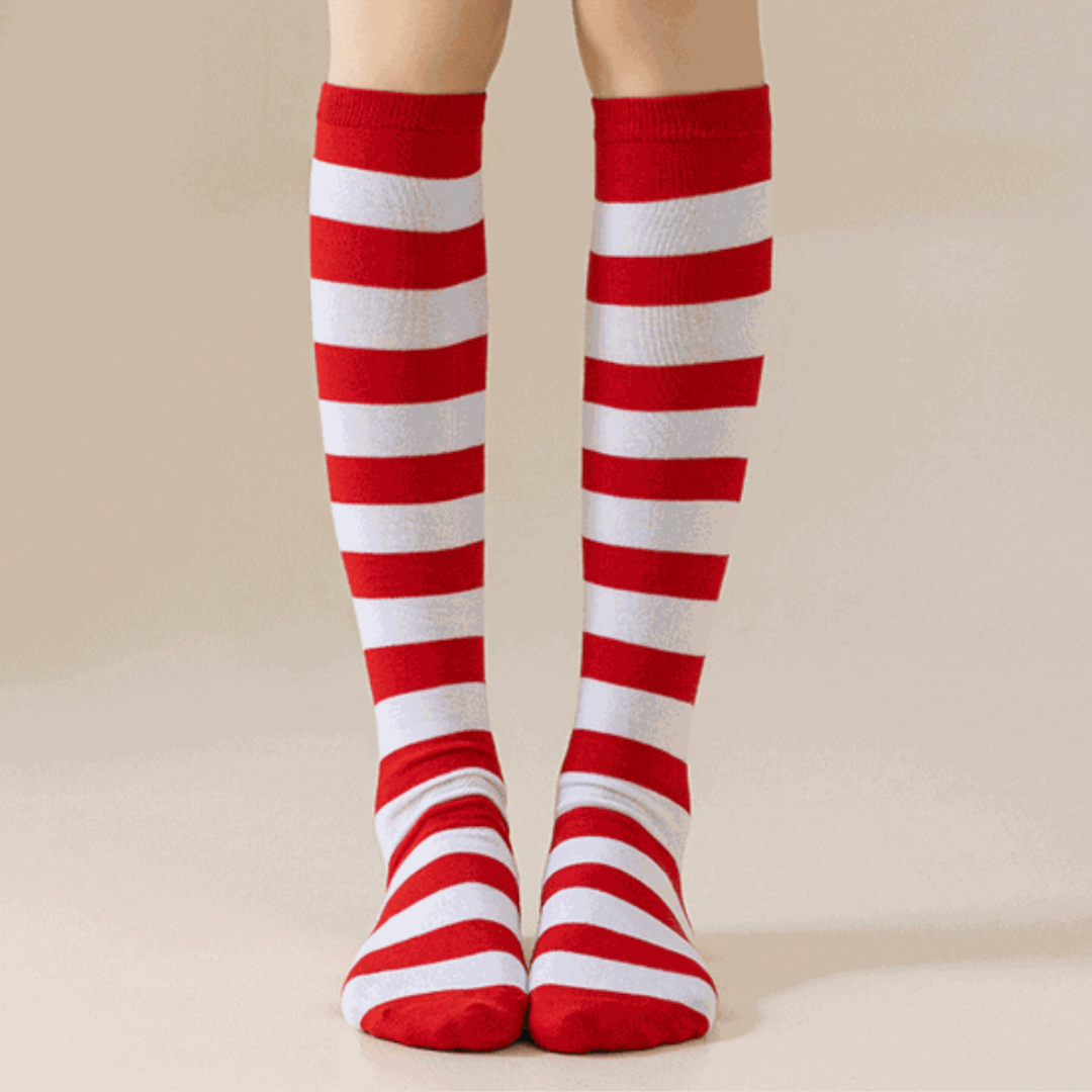 Red and white striped knee socks in candy-cane stripes, featuring a ribbed knit. Worn on legs for a playful look.