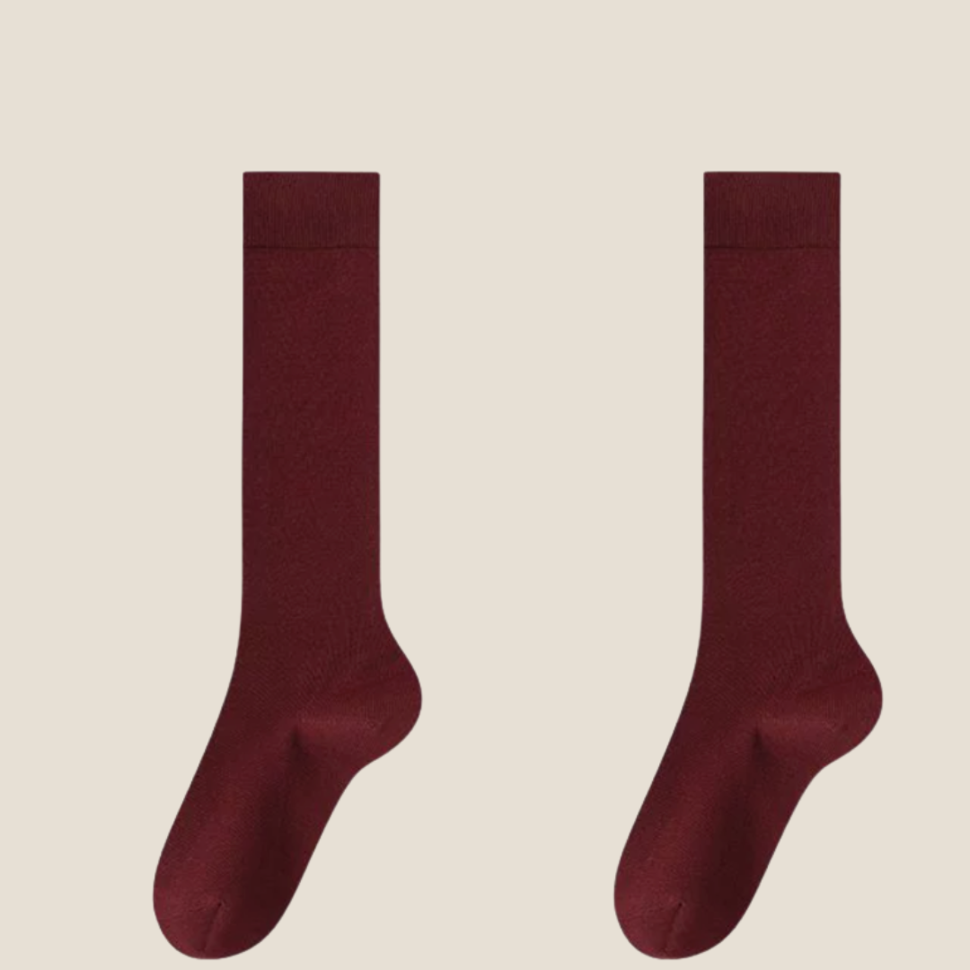 Red knee socks in deep crimson ribbed knit, featuring a cushioned foot. Shown as an upright flat-lay pair.