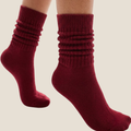 Red slouch socks in burgundy knit, featuring a scrunched slouchy leg. Worn as a pair on the legs.