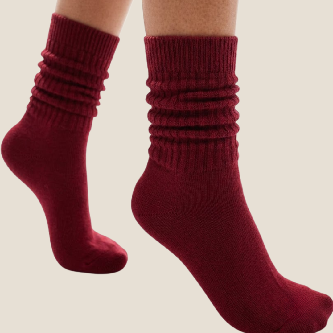 Red slouch socks in burgundy knit, featuring a scrunched slouchy leg. Worn as a pair on the legs.
