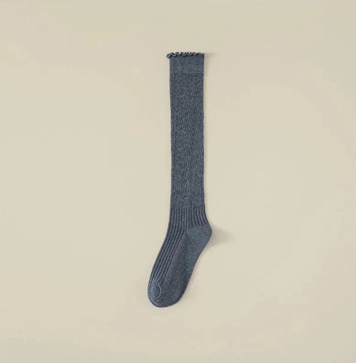 Ruffle knee high socks in denim blue ribbed knit, featuring a ruffle-trim top. Displayed flat to show the frilled cuff.