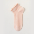 Sheer ankle socks in pink, featuring a delicate frill trim. Shown as a single flat-lay on a light backdrop.