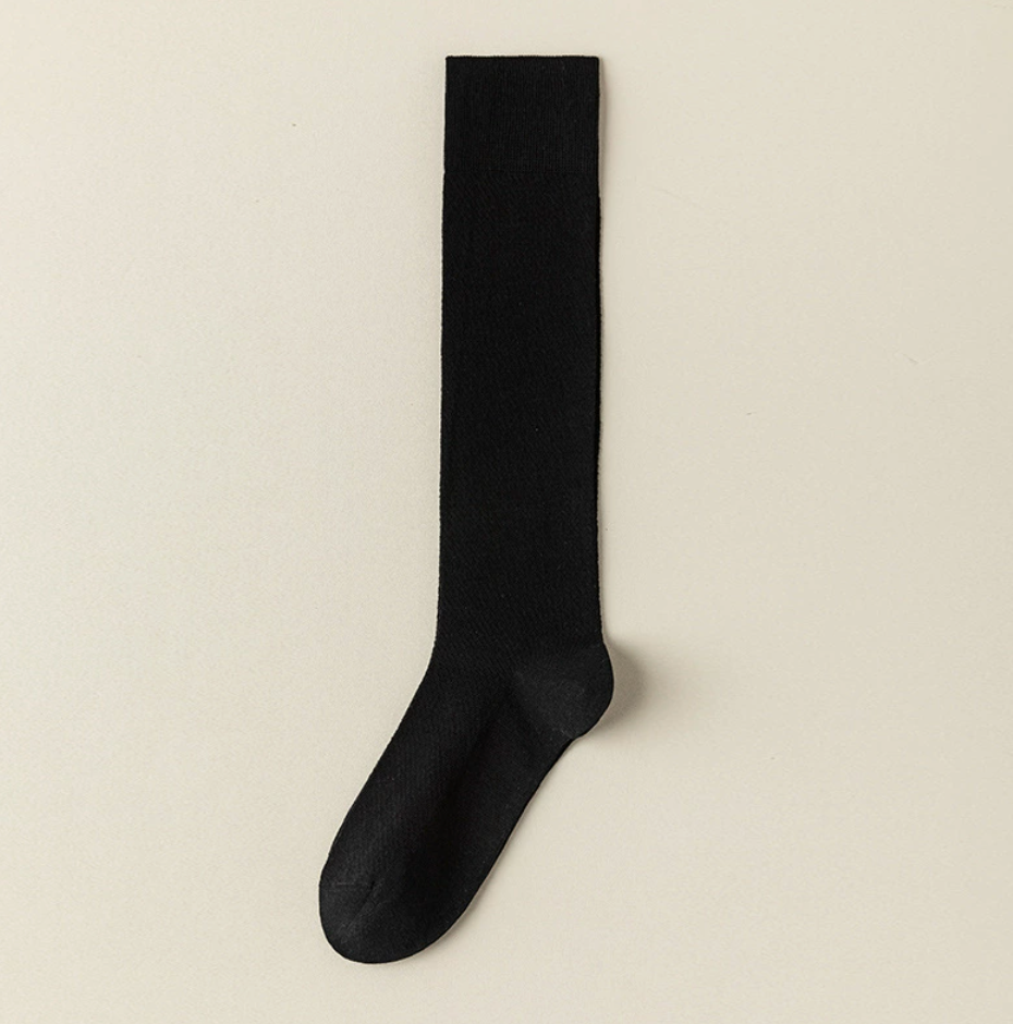 Sheer knee socks in black mesh knit, featuring an airy see-through weave. Displayed flat on a light surface.