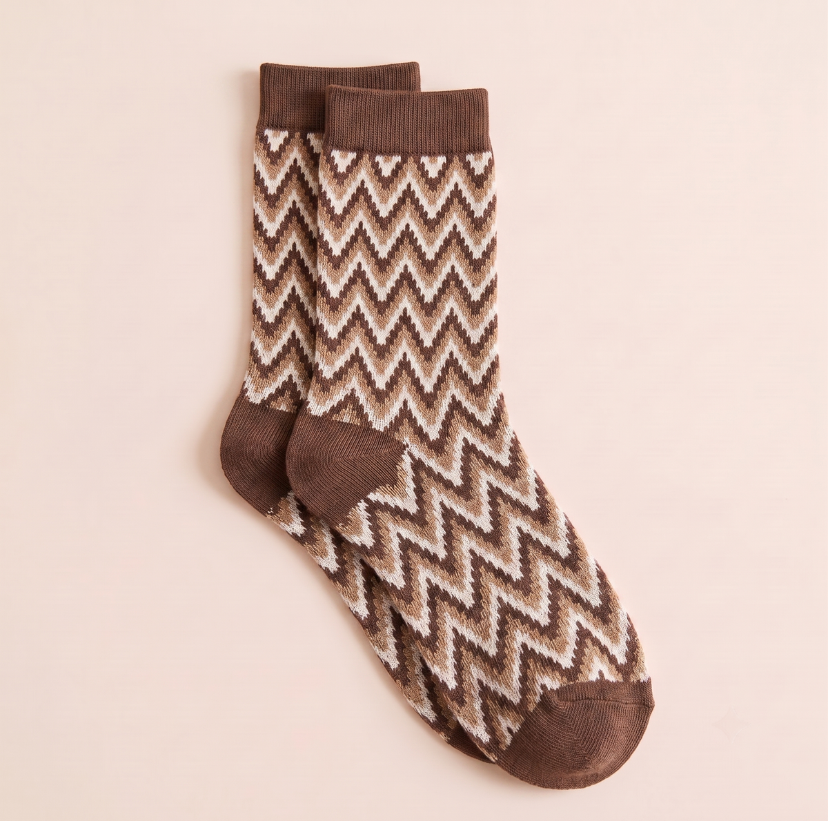 Short boot socks in brown and cream, featuring a zigzag chevron knit. Shown as a flat-lay pair on a warm backdrop.