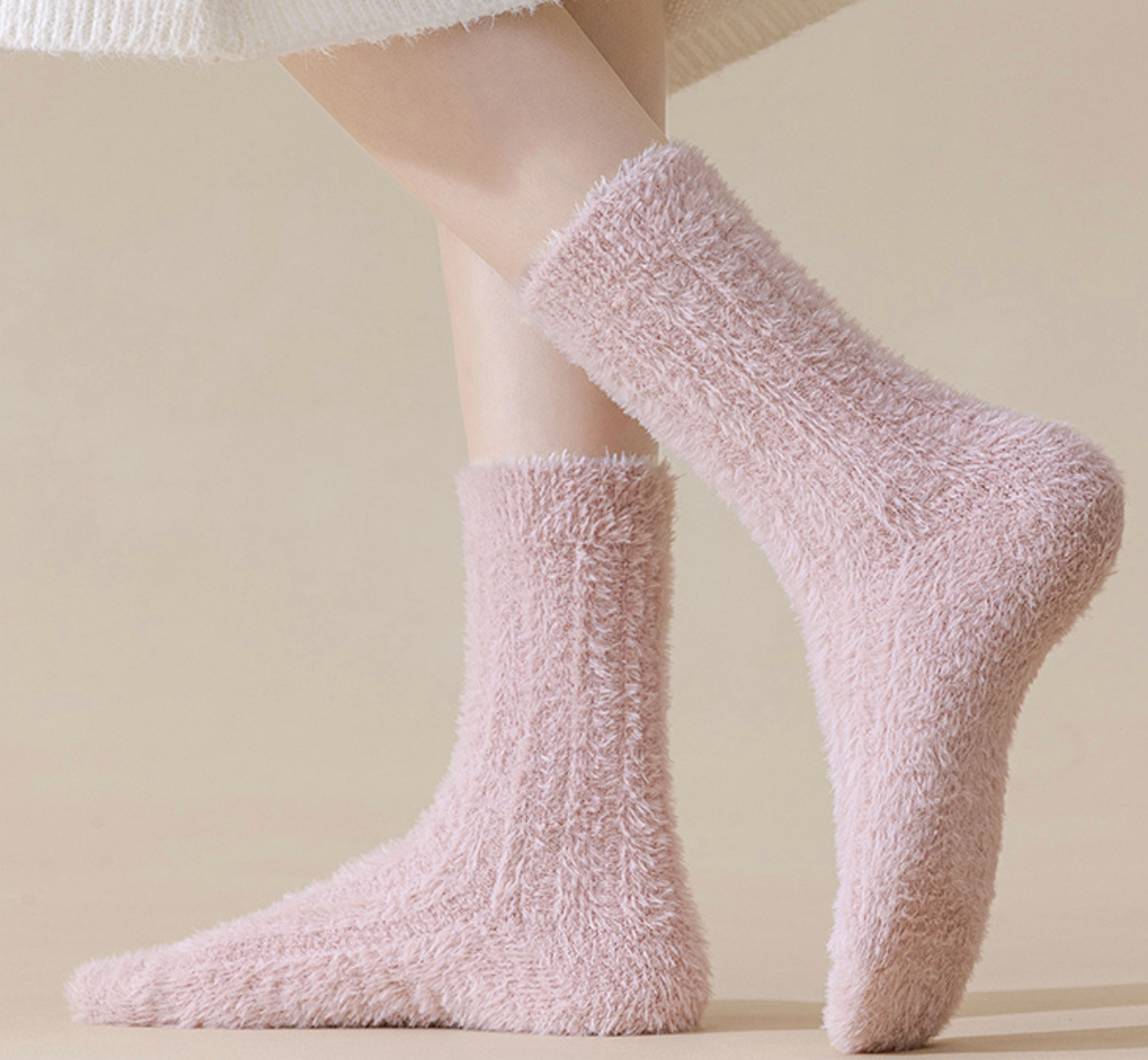 Socks for cold toes in pink plush knit, featuring an ultra-soft fuzzy surface. Worn on feet in a warm side view.