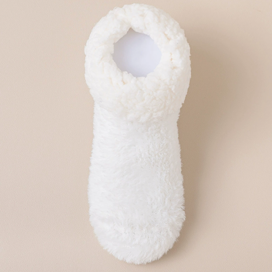 Soft slipper socks in cream, featuring a fluffy plush pile. Displayed flat on a light surface.