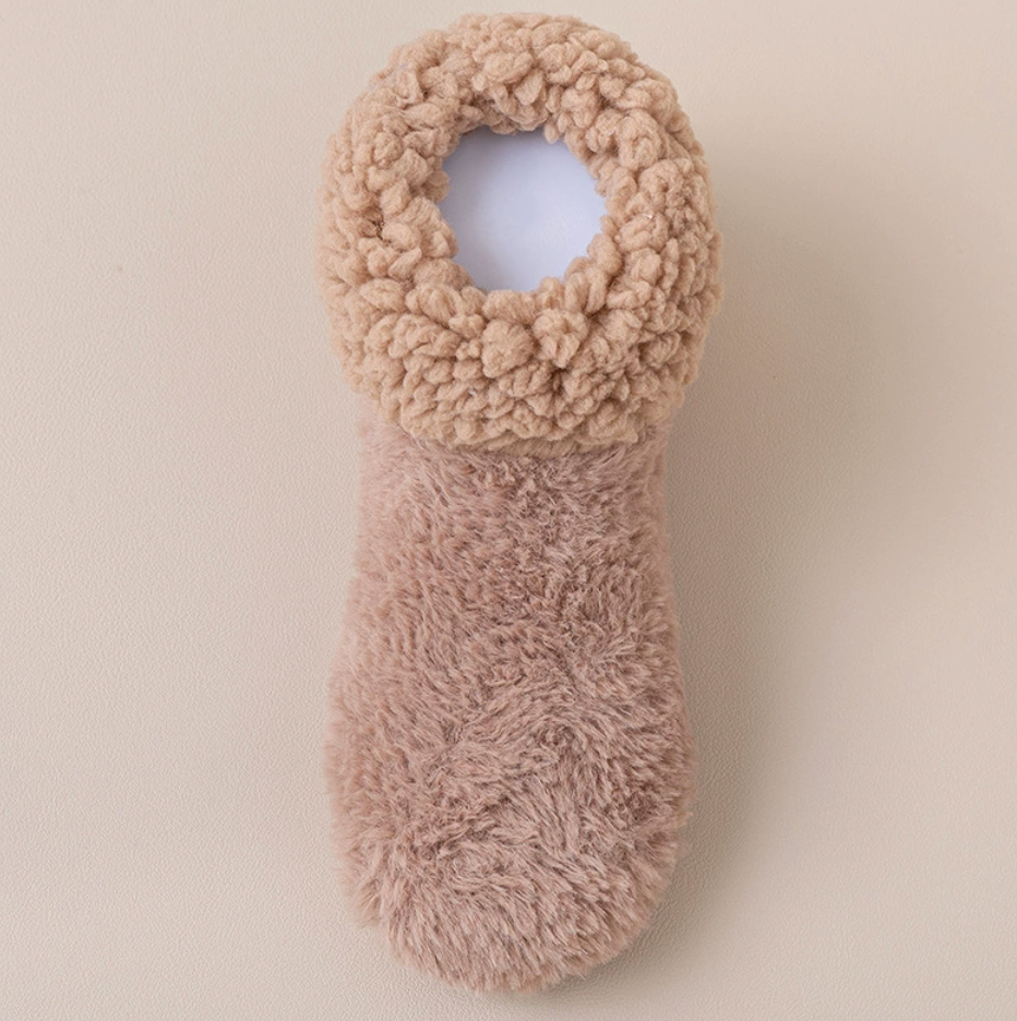 Soft slipper socks in tan, featuring a plush cushioned knit. Shown as a single flat-lay on a neutral backdrop.
