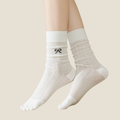Split toe socks in white knit, featuring a two-toe tabi design and bow accent. Worn on the feet in a slouchy style.